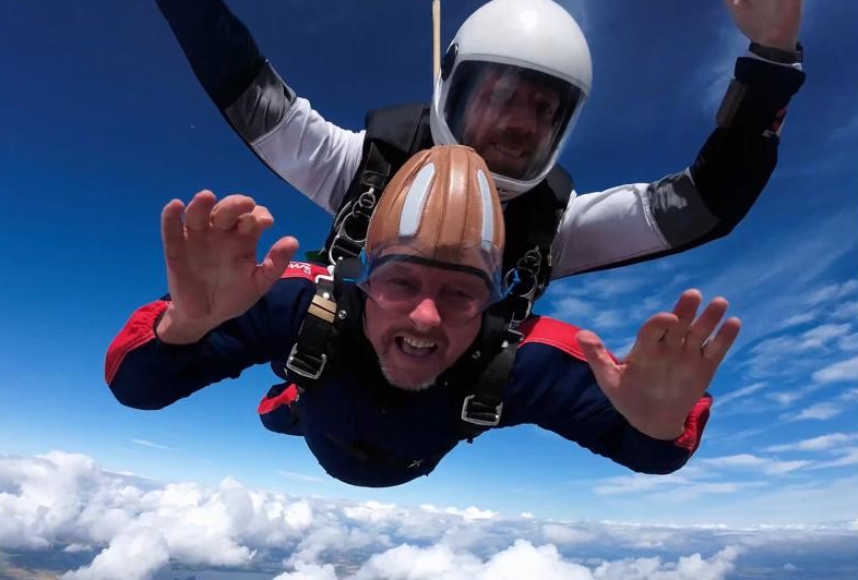 Kidney transplant patient Scott Cather waves to camera during sky dive