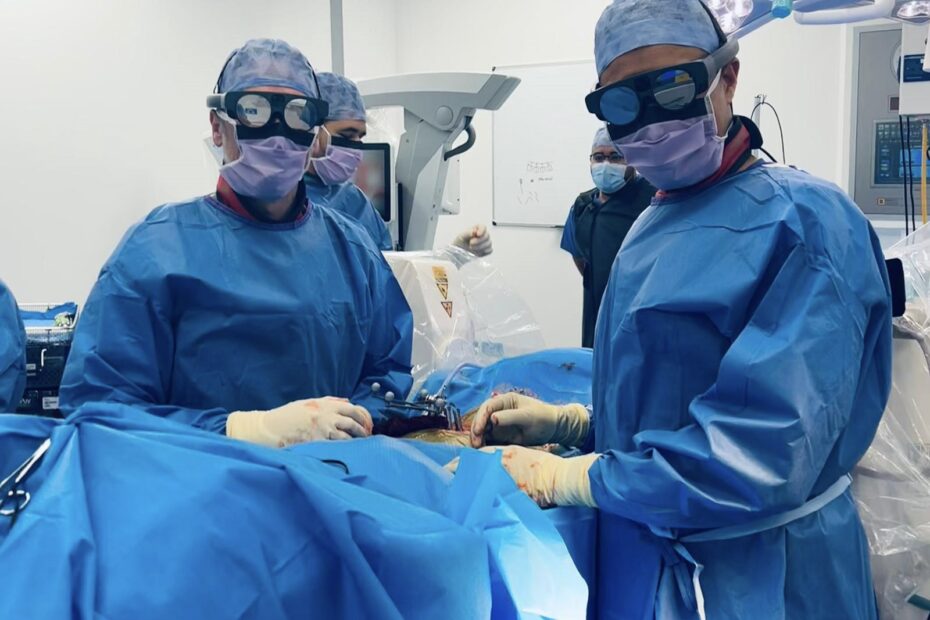 Two surgeons in an operating theatre, wearing the new Mixed Reality goggles.